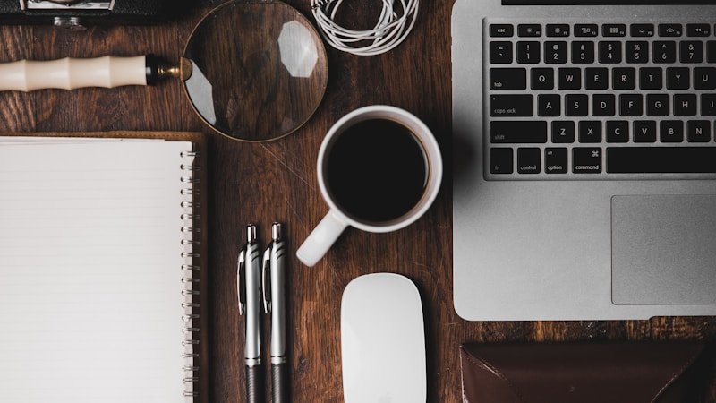 Clean productive workspace with laptop, notebook, and coffee in natural light
